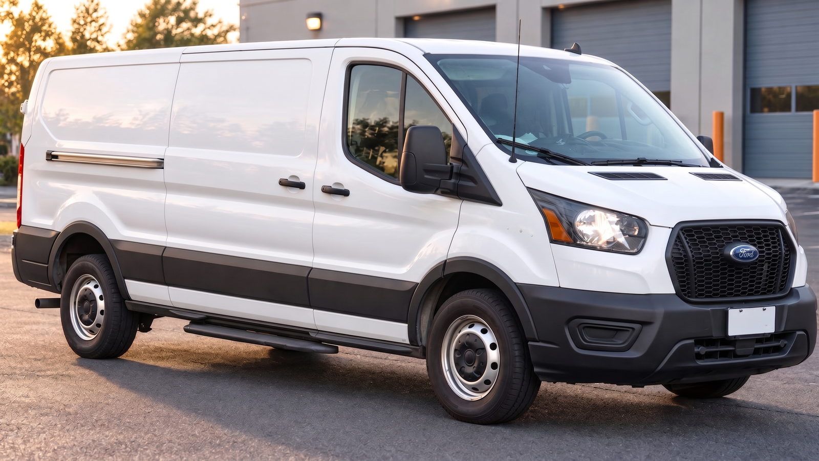 White Ford Transit cargo van with solid cargo panels parked outside a commercial building